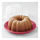 Clear plastic Bundt cake container with a red twist-lock lid, shown closed with a Bundt cake inside, displayed on a white background.