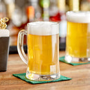Glass beer mug filled with cold beer, shown on a countertop.
