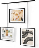 A modern black frame photo display featuring three frames suspended from a horizontal bar by thin rods.