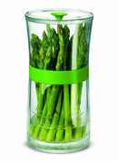 A large, clear herb keeper filled with a variety of fresh green herbs, including sage and rosemary. A green band wraps around the middle, and the base holds water to keep the herbs hydrated.