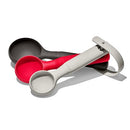 Three OXO Good Grips silicone cookie scoops stacked on a white background. The scoops have gray, red, and black silicone heads and matching comfortable handles with the OXO logo. The gray scoop has a sweep attached.
