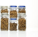 An empty, clear glass Bormioli Rocco Fido square-shaped jar with a vibrant blue lid insert and a metal wire clamp closure.