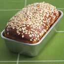 Bread in Nordic Ware natural aluminum rectangular loaf pan with smooth sides on a white background.