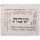 A decorative textile featuring Hebrew text in a circular and rectangular arrangement around the central word "Shabbat," likely used for the Jewish Sabbath.