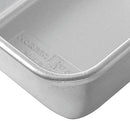 Close up of Nordic Ware natural aluminum rectangular loaf pan with smooth sides on a white background.