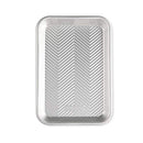 A small, rectangular, natural silver aluminum baking sheet with an embossed chevron or prism grid pattern on the interior surface