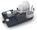 A gray Joseph Joseph Expandable Dish Drying Rack with a removable white cutlery holder and a plated steel wire rack for dishes. The rack is shown in its compact size.