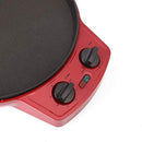 Red electric pizza maker with a cooked pizza inside, lid open, and controls visible.