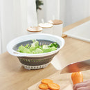 Large, round gray and white collapsible colander filled with colorful pasta.