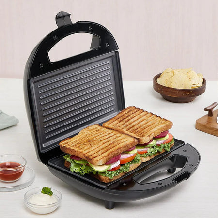 A sandwich maker with a grilled panini inside, showing melted cheese and crisp grill marks.