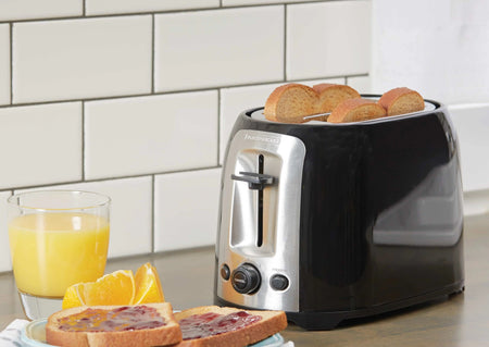 A two-slice toaster with golden brown toast popping up, featuring a stainless steel finish.
