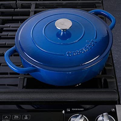 A 5-quart blue enameled cast iron braiser with matching lid, displayed against a stovetop