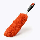 OXO Good Grips hand duster featuring a washable red microfiber head designed to attract and trap dust.
