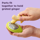 Green oval-shaped Chef'n garlic grater with a stainless steel grating surface.