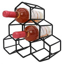 A black metal countertop wine rack designed in a honeycomb/hexagon pattern, securely holding two wine bottles horizontally.