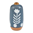 A large, cylindrical stoneware bud vase with a blue glazed background, a white hand-painted floral and dot pattern, and an exposed terracotta base.