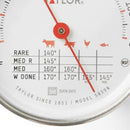Taylor brand classic style meat thermometer featuring a round dial with Fahrenheit markings from 120 to 200 degrees. The dial face includes icons for beef, pork, poultry, and lamb/veal, along with recommended temperatures for different levels of doneness. The thermometer has a stainless steel probe and a clip for oven use.