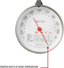 Taylor brand classic style meat thermometer featuring a round dial with Fahrenheit markings from 120 to 200 degrees. The dial face includes icons for beef, pork, poultry, and lamb/veal, along with recommended temperatures for different levels of doneness. The thermometer has a stainless steel probe and a clip for oven use.