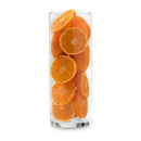 Clear glass vase, cylindrical, filled with fresh orange slices, modern home decor, kitchen accent.
