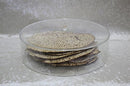 A large, round, clear lucite matzah box with a ridged design and a clear cover with a modern knob.