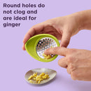 Green oval-shaped Chef'n garlic grater with a stainless steel grating surface.
