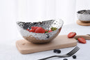 A medium-sized, oval serving bowl with a shiny silver color and a distinctive hammered texture on the entire surface.
