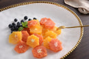 Fruits on a White porcelain oval serving platter with a gold beaded rim displayed on a wooden table