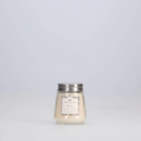 A small, clear glass jar candle with a very light, almost white wax. It has a silver metal lid and a decorative label featuring the scent 'Haven.'