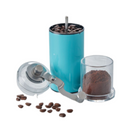 A manual coffee grinder with a clear top and bottom, featuring a vibrant turquoise blue body and a silver hand crank. The background is transparent.