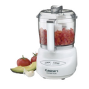 A white Cuisinart Mini-Prep Plus food processor with a clear bowl containing chopped tomatoes, displayed next to raw tomatoes, avocado, and garlic.