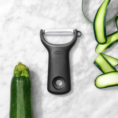 OXO Black peeler on a marble countertop with peeled vegetable