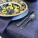 The purple tablecloth draped over a long dining table set .