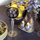 The purple tablecloth draped over a long dining table set for a candlelit dinner with wine glasses and floral centerpieces.