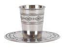 A stainless steel Kiddush cup and matching saucer with a subtle hammered texture and an etched black and silver diamond pattern. The cup is resting on the saucer.
