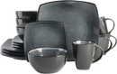 A 16-piece square-shaped dinnerware set in a dark charcoal gray stoneware, showing dinner plates, salad plates, bowls, and mugs.