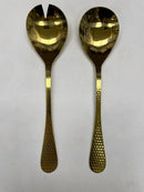 A 2-piece salad serving set consisting of one spoon and one spork/fork. Both pieces have a highly polished gold finish and a distinct hammered texture on the handles.