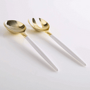 White and gold plastic serving fork and spoon set displayed on a white background.