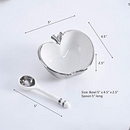 A white ceramic bowl shaped like an apple with a silver rim and stem, accompanied by a white ceramic spoon with silver bands on the handle. Dimensions for the bowl (5" x 4.5" x 2.5") and spoon (5" long) are indicated.
