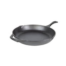 Black cast iron skillet with a long ergonomic handle and helper handle, featuring a smooth cooking surface and dual pour spouts.