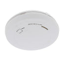 An image of a First Alert Smoke and Carbon Monoxide Alarm, a round, white device with a prominent "First Alert" logo and text reading "SMOKE AND CO ALARM." It features a central circular button or vent with a rectangular opening on the left and a narrow slit on the right. The device is shown at a slight angle against a plain white background.