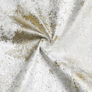 A close-up of a folded jacquard fabric napkin set in a white and gold tree pattern.