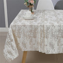 Gold mosaic jacquard tablecloth draped over a dining table set for a formal dinner with candles and place settings.
