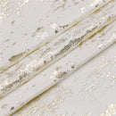 Folded 70" x 108" jacquard tablecloth with gold mosaic print displayed on a white background.