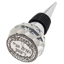 Clear crystal wine cork with an ornament-shaped top on a white background.