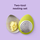 Green oval-shaped Chef'n garlic grater with a stainless steel grating surface.