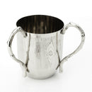 Polished silver metal cup with engraved wood grain texture, featuring two sculpted twig-style handles and a carved knot detail on the side.
